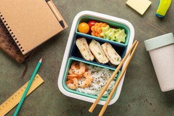 Asian bento box with rice, prawns, omelette tamagoyaki and vegetables. Healthy snack in the office or school. Top view