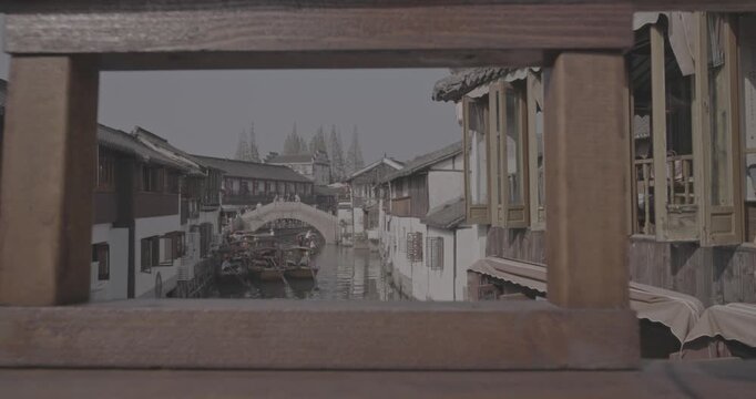 Framed view of a canal bridge with traditional houses and scenic reflections. Zhujiajiao, Shanghai, China