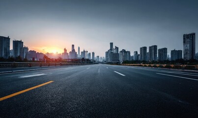 Fototapeta premium Empty road leading to city skyline at sunrise