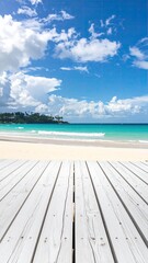 Fototapeta premium White wooden deck overlooking a tropical beach. Bright blue sky, fluffy white clouds, turquoise water, and sandy shore. Perspective is from the deck's surface, looking out towards the ocean