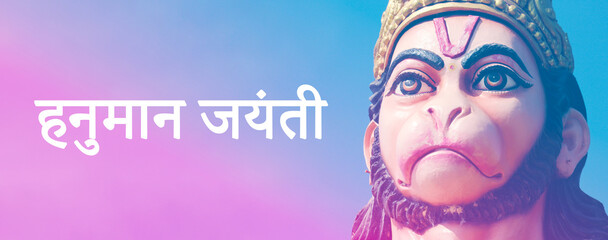 Hanuman Jayanti festival banner template. Close up portrait of powerful Hanuman statue with Hindi...
