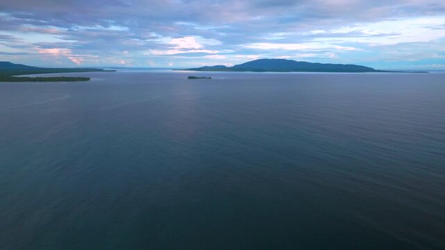 Yuo Mushu Island Cape Wom Public Beach remote untouched coastline tropical jungle forest Wewak aerial drone Papua New Guinea PNG Dogreto Bay morning Pacific Ocean Bismarck Sea blue sky backward motion