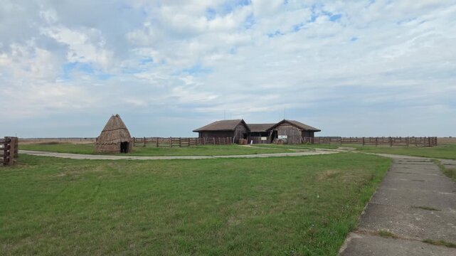 Traditional thatched barn with corral on the endless Hortob&aacute;gy plain on a calm cloudy day in Hungary.