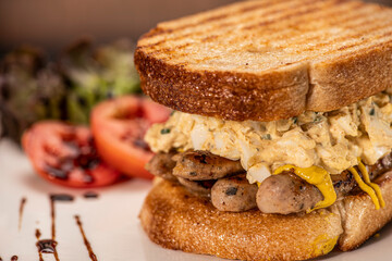 close up picture of breakfast sandwich with sausage and egg salad