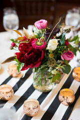 Bold Floral Centerpiece with Candles on Striped Table Runner