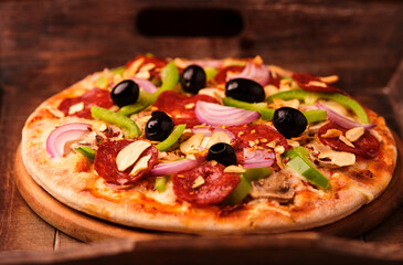 Pizza with salami, mozzarella cheese and jalapeno pepper. Wooden background. Soft focus.	