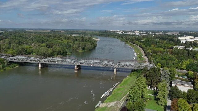 Panoramic aerial view capturing the impressive iron bridge viaduct gracefully spanning the wide Po River in Cremona Lombardy Italy with lush green trees lining the banks