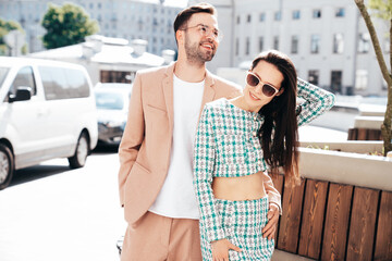 Beautiful fashion woman and her handsome elegant boyfriend in beige suit. Sexy brunette model in...