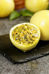 Fresh Passion Fruit Cut in Half Showing Golden Pulp and Seeds on Slate Stone Board