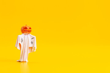Spooky Pumpkin Head Ghost Figurine on Yellow Background