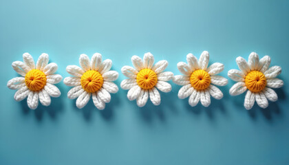 Obraz premium Handmade crochet daisies crafted with white wool, yellow centers on vibrant blue background. Amigurumi-style floral pattern features side lighting, creating charming, textured look perfect for
