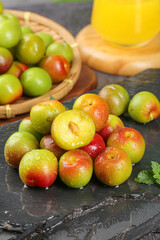 Fresh Ripe Plums with Water Drops on Slate Stone Surface Half Cut Red Green Yellow Fruit