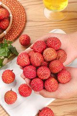 Fresh Lychee Fruits from Guangzhou China - Tropical Asian Fruit in Hands on Wooden Background