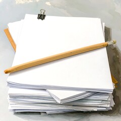 Stack of blank papers with pencil and clip