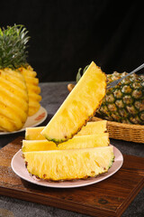Fresh Pineapple Slices on Plate with Whole Tropical Fruit on Wooden Cutting Board