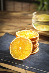 Hand-dried orange citrus slices on slate board - natural dehydrated fruit snacks and food preservation concept