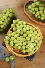 Fresh Green Grapes in Wicker Basket on Wooden Table - Healthy Organic Fruit Harvest