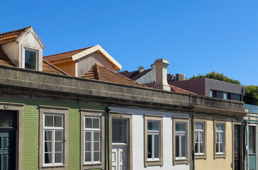 Fototapeta premium Row of traditional European houses with tiled and painted facades, old roof tiles, and chimneys,