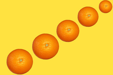 黄色い背景に斜めに並んだみかん