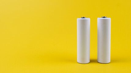 White metal AA-size batteries isolated on yellow background