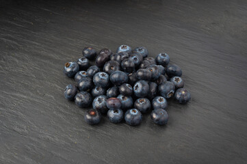Blueberry on black plate. Fresh blue berry fruits, bilberry group on dark background