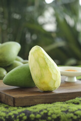 Fresh Hainan Ivory Mango Sliced Raw Fruit Display with Traditional Sauce on Wooden Board