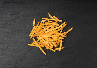 Fried chips sticks, finger potato chips, golden shoestring fries pile, French fries