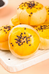 Handmade Golden Egg Yolk Pastry Buns with Black Sesame Seeds on Wooden Board