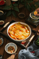 Spicy Wide Vermicelli Noodles in Hot Pot with Traditional Asian Tea Service and Handmade Ceramic Bowls