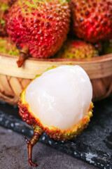 Fresh Hainan Concubine Lychee Fruit with White Flesh Peeled on Black Slate Background