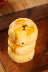 Traditional Egg Custard Pastry Dessert with Black Sesame Seeds on Wooden Background