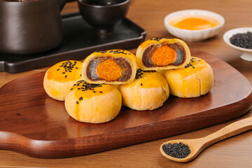 Handmade Chinese Mooncakes with Egg Yolk and Sweet Red Bean Paste Filling on Wooden Board