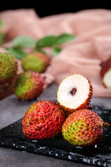 Fresh Hainan Lychee Fruits on Slate Board - Tropical Asian Delicacy with White Flesh and Red Textured Skin