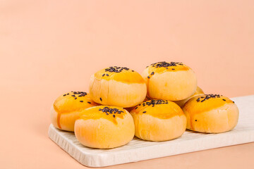 Traditional Asian Egg Yolk Pastries with Black Sesame Seeds on Marble Board