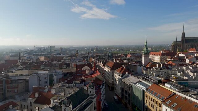 Low aerial drone flyover skimming the historic rooftops near N&aacute;měst&iacute; Svobody (Freedom Square) in Brno, South Moravia, Czechia, on a clear day.
