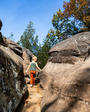 Child hiking narrow path through boulders at Garden of Gods