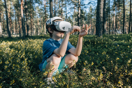 Child in virtual glasses looks at flowers