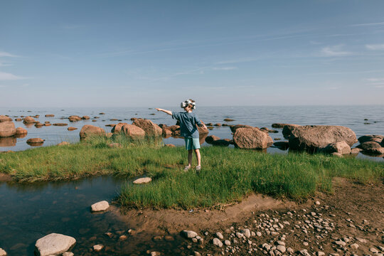 Child in virtual glasses on seashore