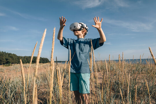 Man in virtual glasses in field with dry plants