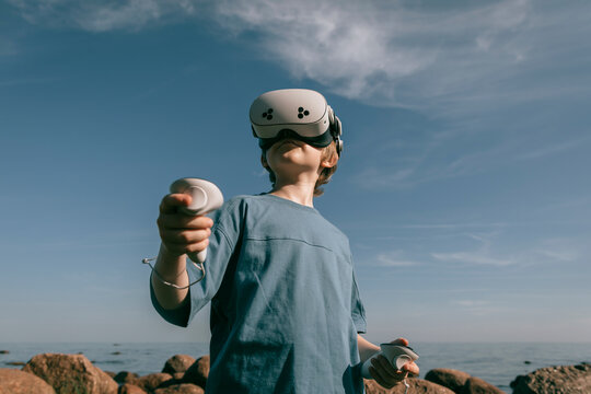 Man in virtual glasses with joysticks plays