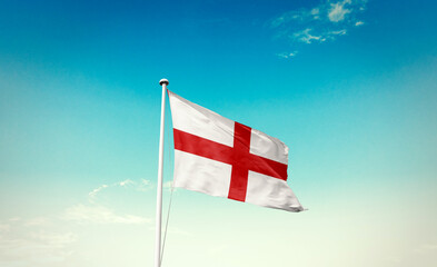 England flag waving in blue sky with mast.