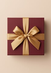 Elegant red gift box with gold satin ribbon bow on beige background
