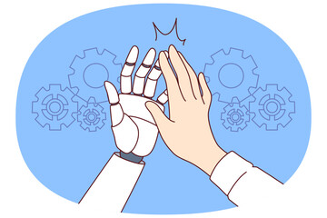 Collaboration man and AI robot making high-five gesture after successfully completed task. Hands of business manager and humanoid helping to develop production thanks to AI or artificial intelligence