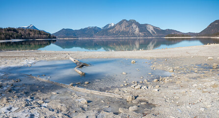 Lake Walchensee with low water level in a dry winter season with less snowfall, bavaria
