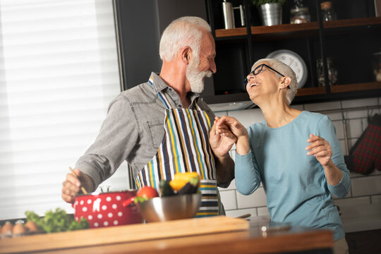 Cute senior couple dancing in the kitchen