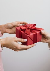 Red gift box exchange between two female hands with pink nails