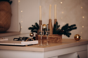 Two glasses of champagne on the table at Christmas with decorations of Christmas trees