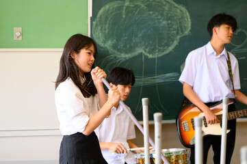 文化祭に向けてバンド練習をする生徒たち　学校の教室での青春イメージ