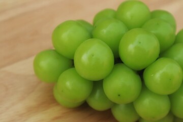 Fresh Shine Muscat or Vitis grapes close up, isolated on wooden backgroun