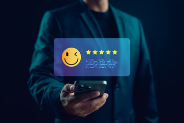 Customer showing five-star feedback on mobile phone with smiley face emoji, representing high...